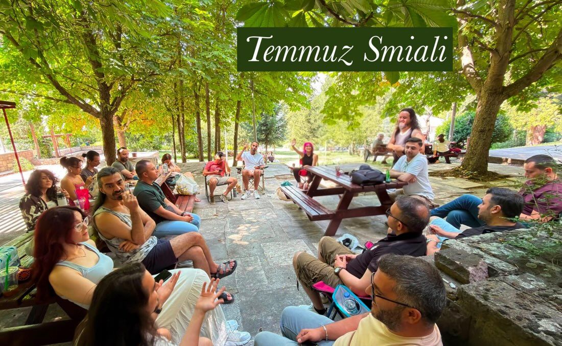 Ağaçların gölgesindeki Temmuz Smial'i; üstte "Temmuz Smiali" yazıyor.