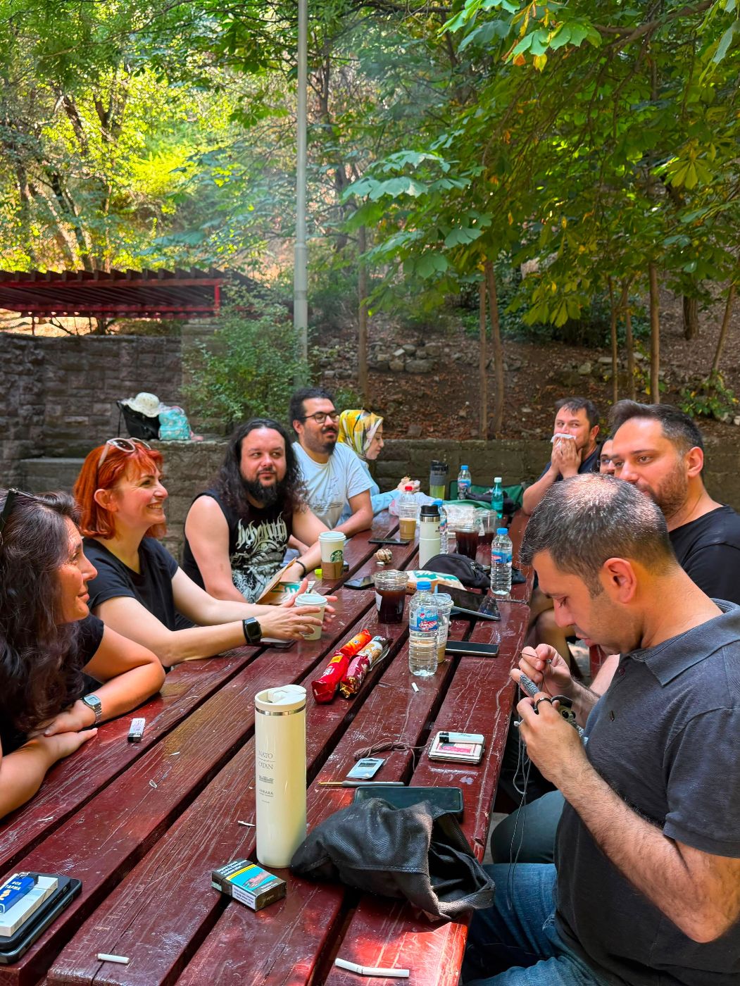Uzun masanın etrafında sohbet eden Smial katılımcıları.